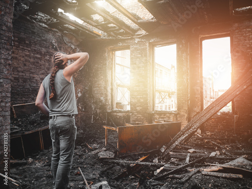 Fotografía Man house owner stands inside his burnt house interior with burned furniture in