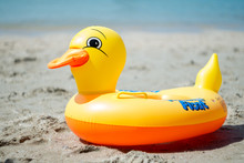 Yellow Duck Swim Ring On The Beach