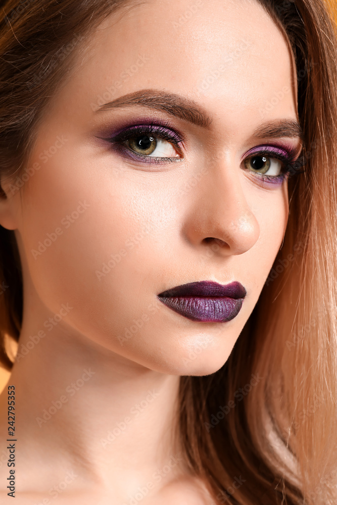 Beautiful young woman with makeup in violet tones, closeup