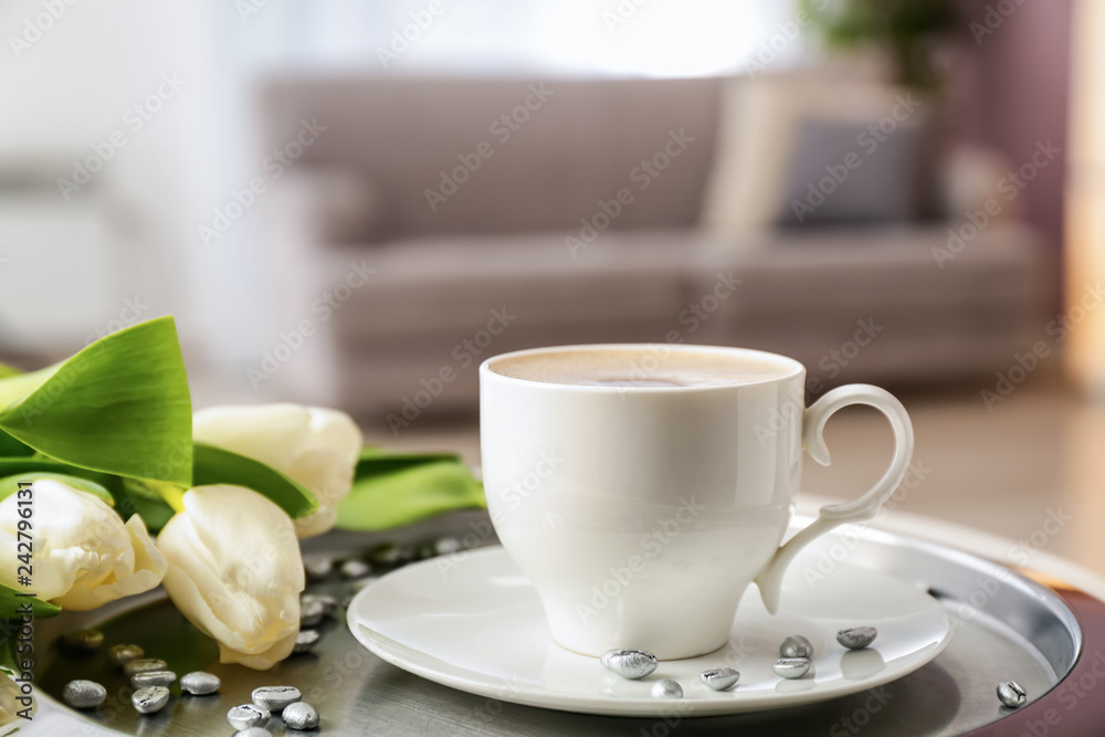 Tray with cup of coffee and beautiful flowers on table