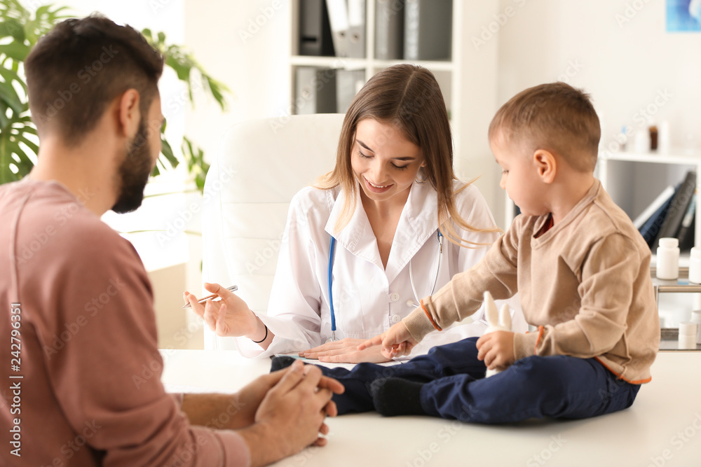 Young father with his little son visiting doctor in clinic