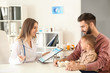 © Pixel-Shot - Young father with his little son visiting doctor in clinic