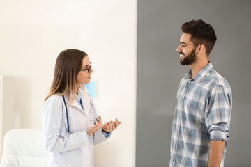 Female doctor working with male patient in clinic