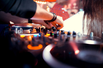 Dj mixes the track in the nightclub at a party. In the background laser light show