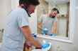 © gpointstudio - Man cleaning his bathroom and talking by mobile phone