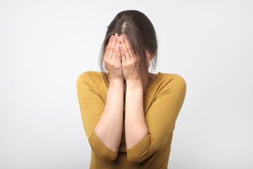 Girl in yellow clothes covered her face.