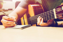 Romantic Guitar. Writing Note Musician Or Married Man Plays Guitar On A Black Sofa At Home.