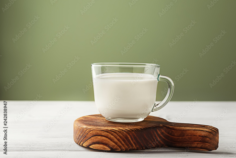 Glass cup of fresh milk on wooden table