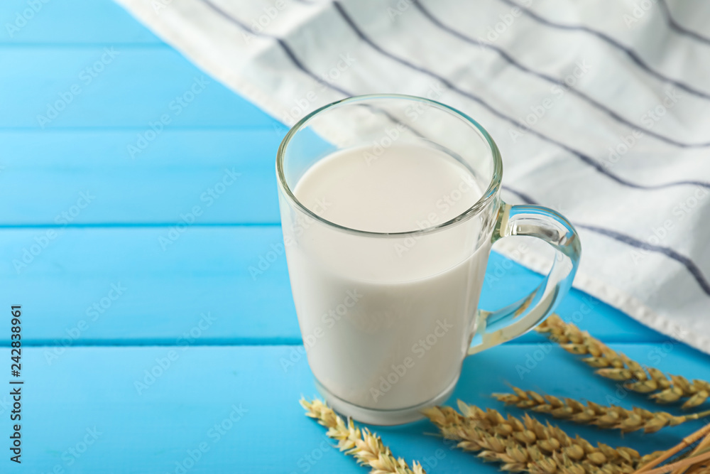 Glass cup of fresh milk on wooden table