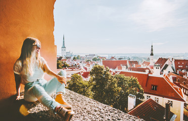 Wall Mural - Woman sightseeing Tallinn city landmarks  vacations in Estonia travel lifestyle girl tourist relaxing at viewpoint Old Town aerial view architecture