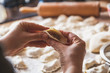 hands of woman make dumpling over granite table