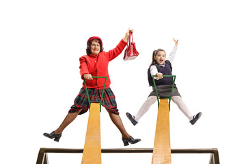 Sticker - Cheerful grandmother and granddaughter having fun on a seesaw