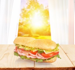 Wall Mural - Long baguette sandwich with lettuce, vegetables, ham, and cheese