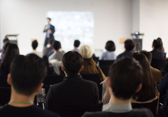 Fototapete - Seminar Audience in Training Room Watch Presentation. Speaker in Meeting at Business Event. Young People in Room with Audience Who Listen to Speaker. Expert Presenter Giving Talk to Entrepreneurs.