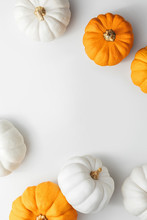 White And Orange Pumpkins On A White Background, Creative Flat Lay Thanksgiving Concept, Top View With Copy Space