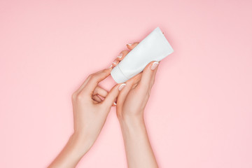 cropped view of female hands with hand cream isolated on pink