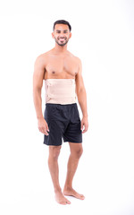 Wall Mural - shirtless man in studio with white background wearing orthopedic corset