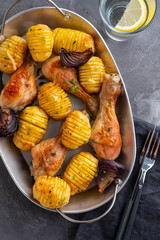 Wall Mural - Barbecued chicken leg with boiled potatoes and vegetables on black background. Copy space. Top view.