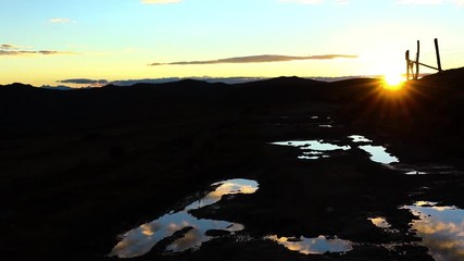 Wall Mural - Sunset on an old road flooded with puddles of water in the central Peruvian Andes at sunset