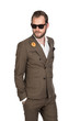 © _robbie_ - Cool trendy businessman in a brown suit, white shirt and sunglasses walking against a white background with a focused tough look.