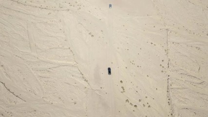 Wall Mural - Off-road vehicle on desert road - Aerial footage.