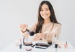 © bunditinay - Beautiful asian woman blogger is showing how to make up and use cosmetics. In front of the camera to recording vlog video live streaming at home.Business online influencer on social media concept.
