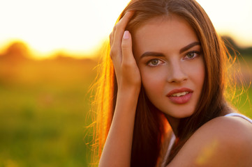 Wall Mural - Beautiful young woman on nature over summer sunset.