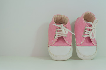 A pair of pink baby girl shoes on white background