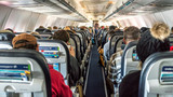 Fototapeta  - Passengers seated inside of a commercial passenger airplane. Travelers going across the globe. 