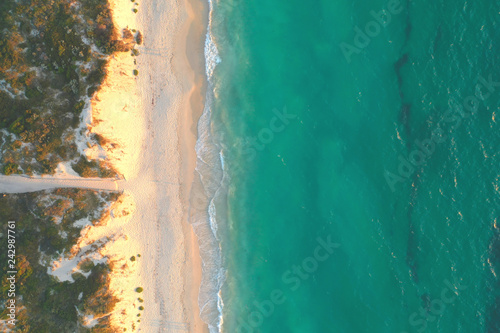 Plakat Widok z lotu ptaka nieskazitelnie białej piaskowatej plaży z piękną błękitnej zieleni turkusu wodą przy zmierzchem