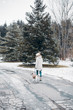 © litts - Active winter leisure - woman walking with dog in snowy park. Instagram style photo.