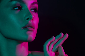 Young beautiful girl with purple and green neon lighting