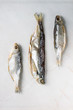 Dried fish or stockfish over white marble background. Flat lay, space