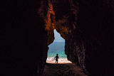 Fototapeta Zwierzęta - Silhouette of a child running through a cave in Algarve, Portugal.
