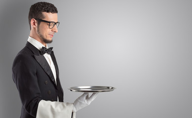 Wall Mural - Waiter serving with white gloves and steel tray in an empty space
