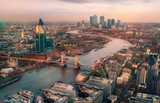 Fototapeta Fototapeta Londyn - London view at sunset. Panorama include river Thames, Tower bridge and City of London and Canary Wharf  buildings.