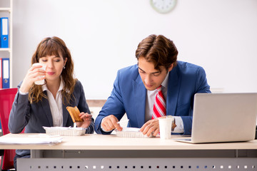 Two colleagues having lunch break at workplace