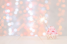 One Cupcake With Sparkler And Fairy Lights. Festive Background With Copy Space For Text