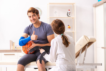 Wall Mural - Handsome basketball player visiting female doctor traumatologist