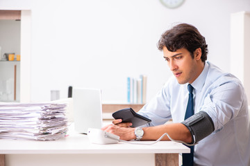 Man under stress measuring his blood pressure