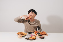 Portrait Of Asian Man Sitting And Snacking Donuts Isolated Over White Background. Fat Man Diet Concept