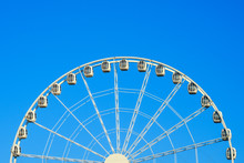 Big Beautiful Ferris Wheel In The Park Against The Blue Sky.