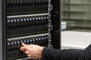 Male IT Technician Checking SAN harddrives in Datacenter