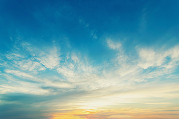 Sky blue and orange light of the sun through the clouds in the sky