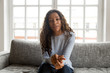 © fizkes - Serious friendly african woman internet teacher tutor looking at camera talking, black mixed race millennial female vlogger speaking making video call vlog, online job interview at home, portrait