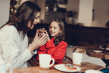 Mama and daughter heaving breakfast in cafe