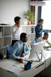 © alfa27 - African american man working on his personal computer, surrounded by his colleagues in office.Handsome young man at his desk.