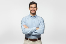 Modern Business Man In Casual Blue Shirt Standing With Crossed Arms, Isolated On Gray Background