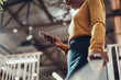 © Yakobchuk Olena - Charming afro american lady in yellow sweater using smartphone