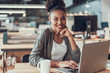 © Yakobchuk Olena - Charming afro american girl using laptop at modern office